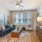 a living room with a blue couch and a fan